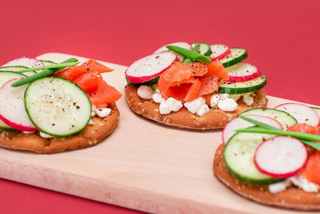 Cracker sandwiches with salmon cucumber radish cottage cheese and green onions