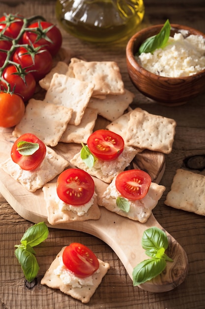 Crackers met zachte kaas en tomaten. gezond voorgerecht