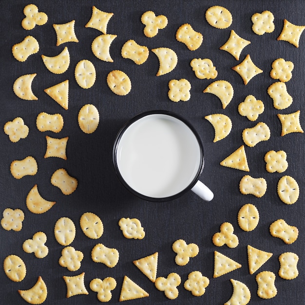 Crackers and milk on black stone table