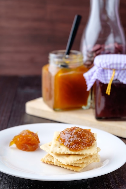 Photo crackers with orange jam on wooden background