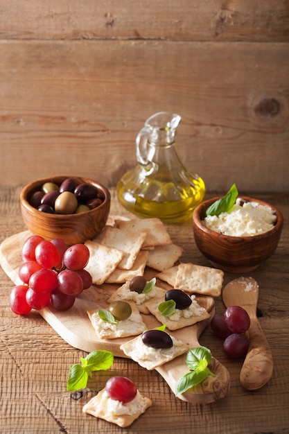 Crackers with soft cheese olives grapes. healthy appetizer