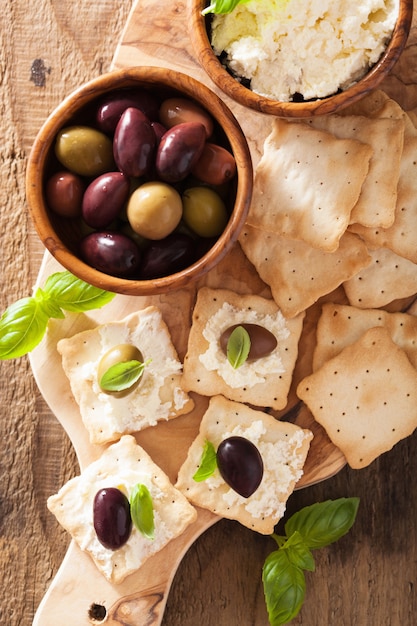 Cracker con formaggio morbido e olive. antipasto sano