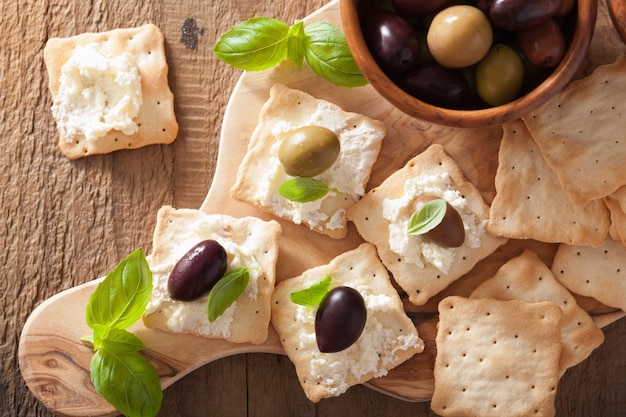Cracker con formaggio morbido e olive. antipasto sano