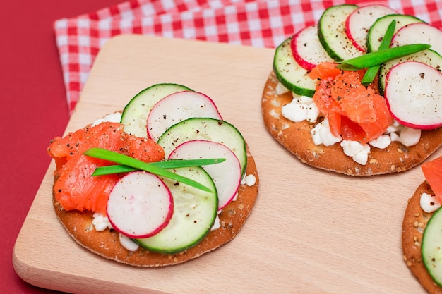 Crackersandwiches met zalm komkommer radijs kwark en groene uien