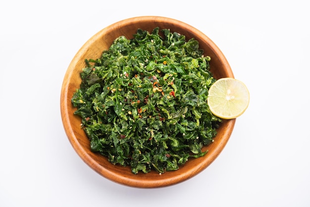 Crackling Spinach or crispy Palak is an Indian starter, served in a bowl or plate with lemon slice