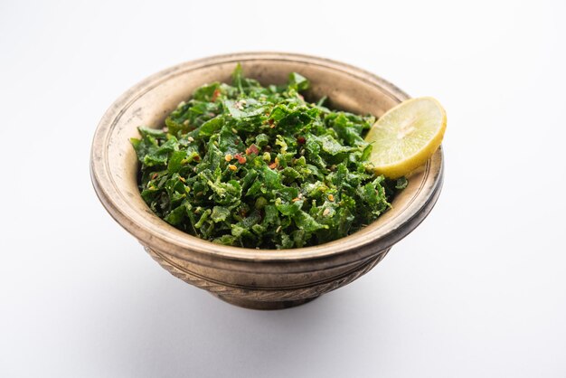 Crackling Spinach or crispy Palak is an Indian starter, served in a bowl or plate with lemon slice