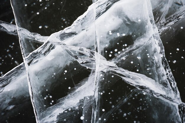 Cracks in the ice of the frozen lake. Macro image, selective focus. Beautiful winter nature