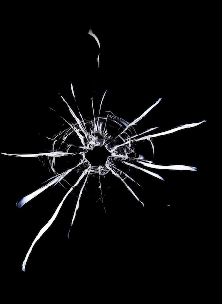 Фото Трещины в стекле на черном фоне пулевое отверстие в окне на темном фоне