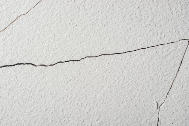 Cracks in the white plastered wall.