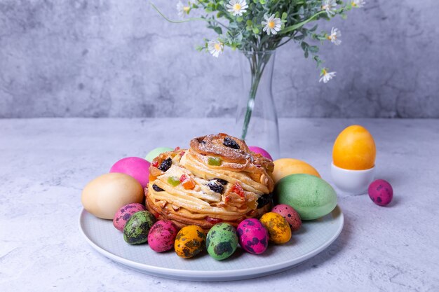 Craffin (Cruffin) met rozijnen, noten en gekonfijt fruit. Easter Bread Kulich en beschilderde eieren. Paasvakantie. Detailopname.