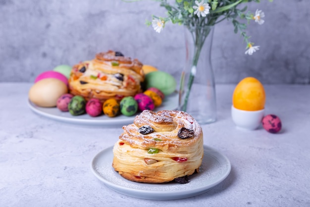 Краффин (Cruffin) с изюмом, орехами и цукатами. Хлеб пасхальный Кулич и крашеные яйца. Пасха. Крупный план.