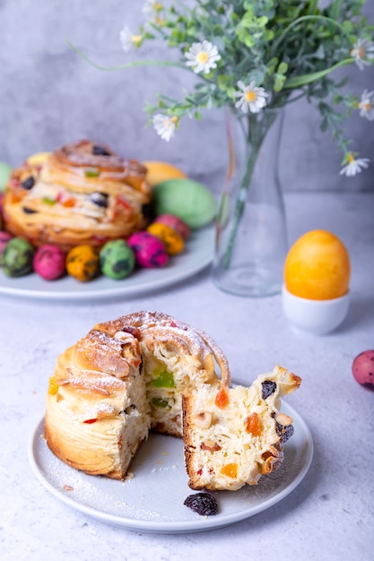 Craffin (Cruffin) with raisins, nuts and candied fruits. Easter Bread Kulich and painted eggs. Easter Holiday. Close-up.