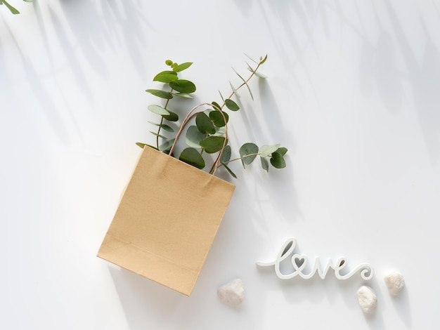 Craft bag with wintertime eucalyptus and white Helleborus flower and wood word love