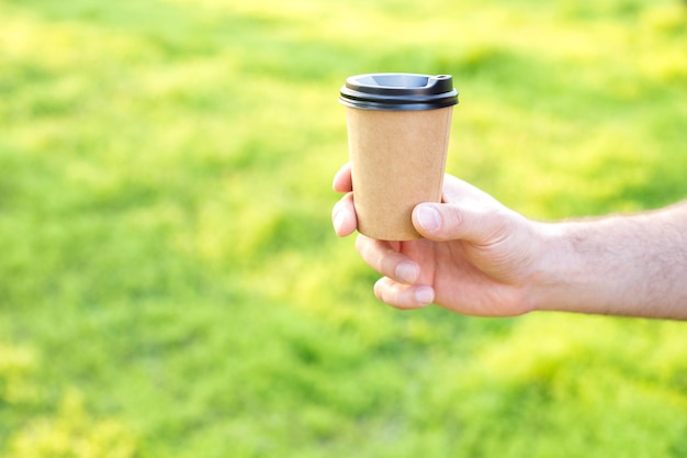 A craft beaker in his hand on a green background free space for text