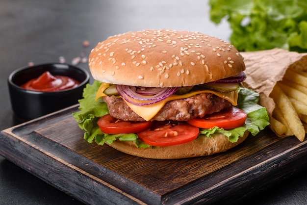 Hamburger di manzo artigianale e patatine fritte su sfondo nero