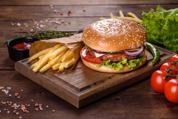 Hamburger di manzo artigianale e patatine fritte su sfondo nero