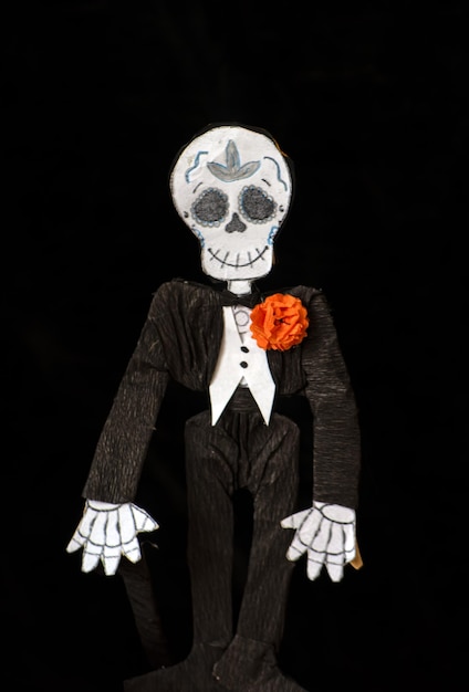 Cempasuchil 꽃과 함께 우아한 남자로 옷을 입은 catrin 또는 두개골의 공예