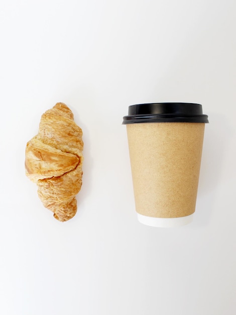 Craft coffee cup with croissant on white background