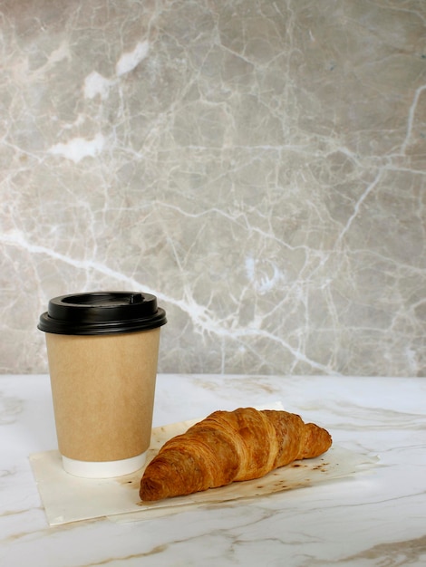 Craft coffee cup with croissant on white background