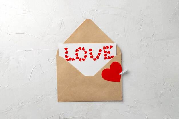 クラフト封筒、愛のメモ、小さな赤い紙の心で作られた愛という言葉
