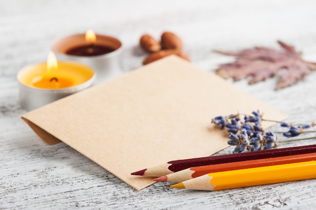 Craft envelope and pencils, lit candles