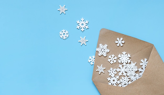 青い背景に雪片のクラフト封筒。