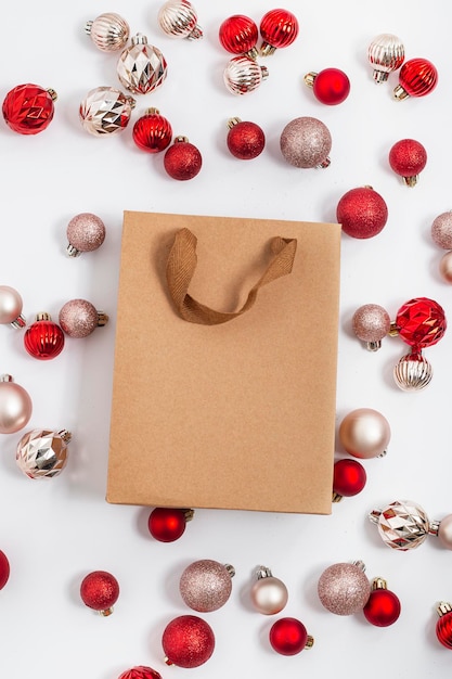 Craft gift bag, decorative balls on a white background. Top view, flat lay.