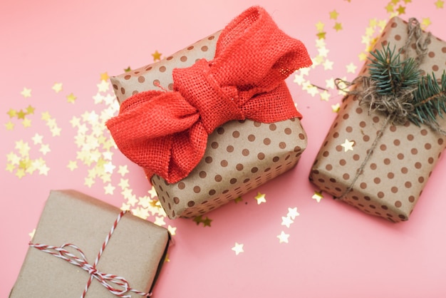 Craft gifts with red bow on pink pastel with gold confetti