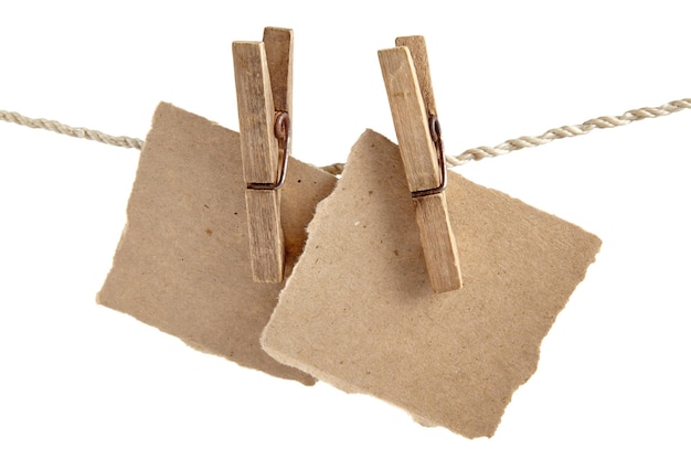 Craft note paper pinned with an old wooden clothespin on a rope on a white background