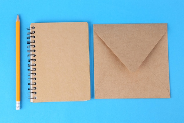 Craft notebook and envelope on blue background