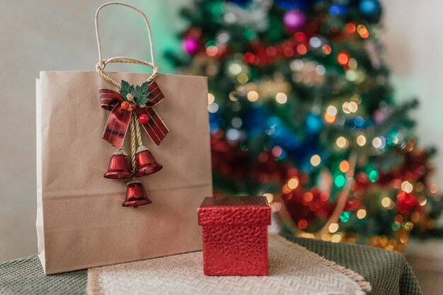 Craft package with a gift on the background of a Christmas tree