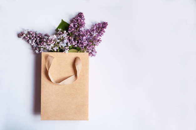 Craft package with purple lilac branches inside on a white background