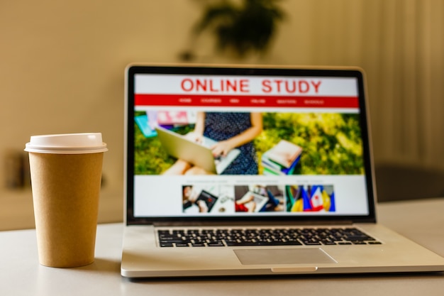 Photo craft paper coffee cup near laptop, study online