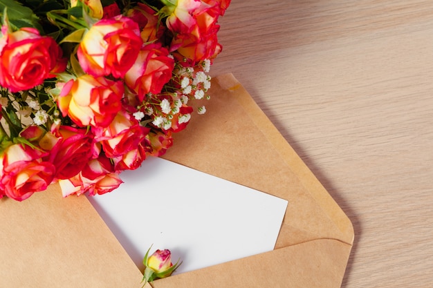 花の束とクラフト紙の封筒、母の日のための空白のグリーティングカード