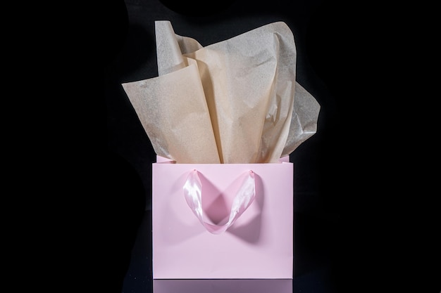 Craft paper gift bag with tissue paper isolated on a black background