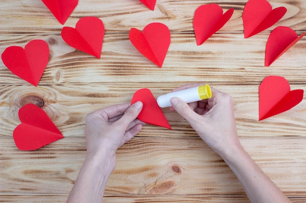 Foto cuore di carta artigianale tra i palmi per san valentino. istruzioni passo passo. regalo fai da te.