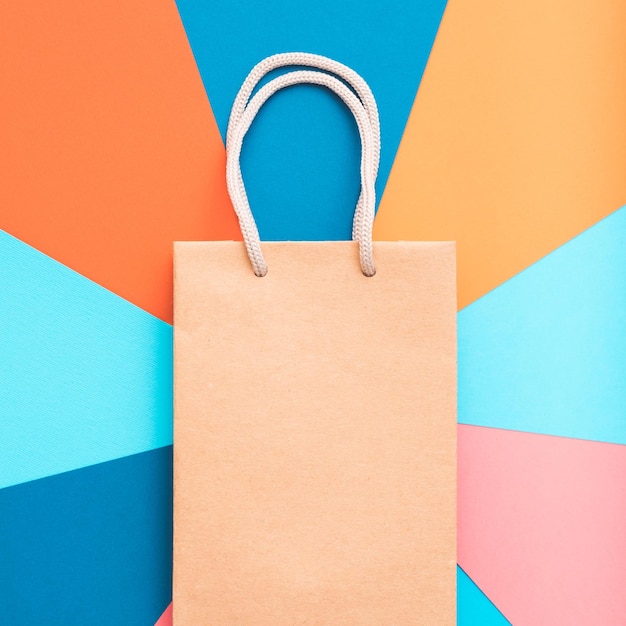 Ремесленная бумажная сумка для покупок на красочном геометрическом фоне подарки и подарки покупают концепцию пространства для копирования