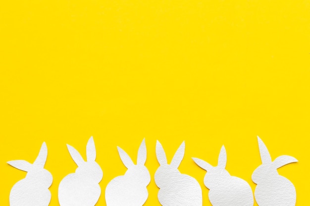 Crafting rabbits on Yellow paper background top view copy space