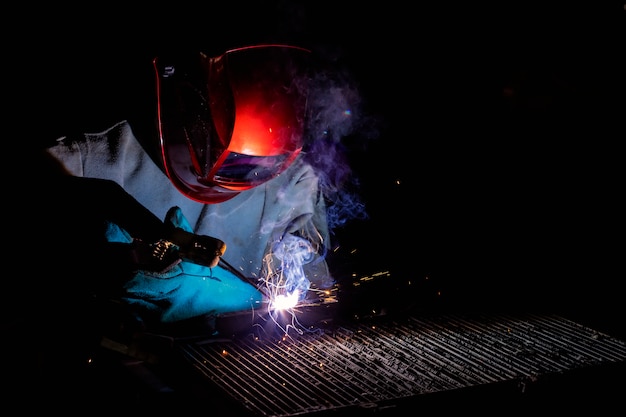 A craftman is welding with workpiece steel.