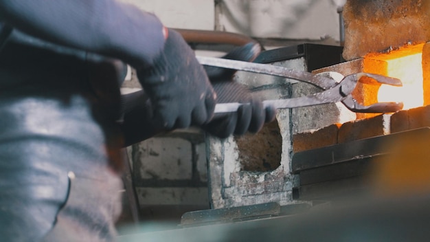 Craftsman blacksmith working with steel in forge