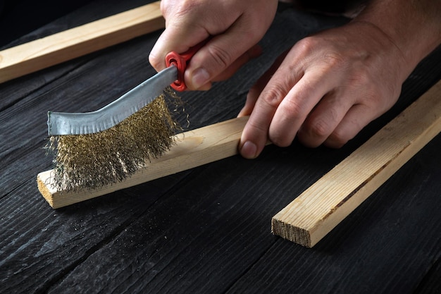 Фото Ремесленник чистит деревянную доску абразивными инструментами