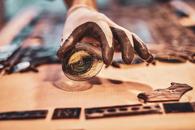 Craftsman is aplying another peace of stained glass to the broken antique window.