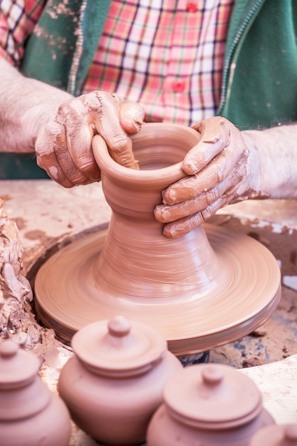 Ремесленник делает глиняный горшок своими руками