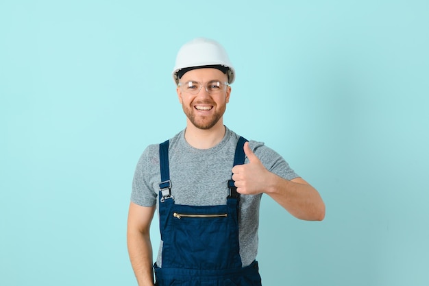 Craftsmen or electrician man over isolated blue background giving a thumbs up gesture