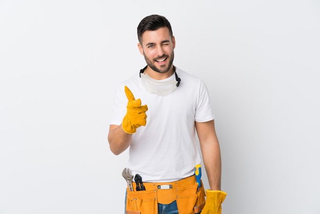 Craftsmen or electrician man over isolated white wall points finger at you
