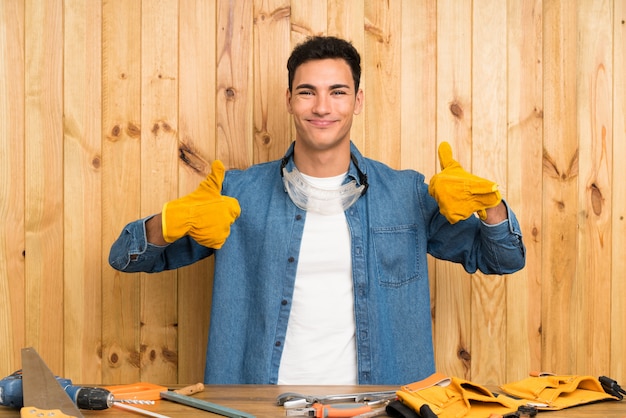 Craftsmen man over wood wall giving a thumbs up gesture
