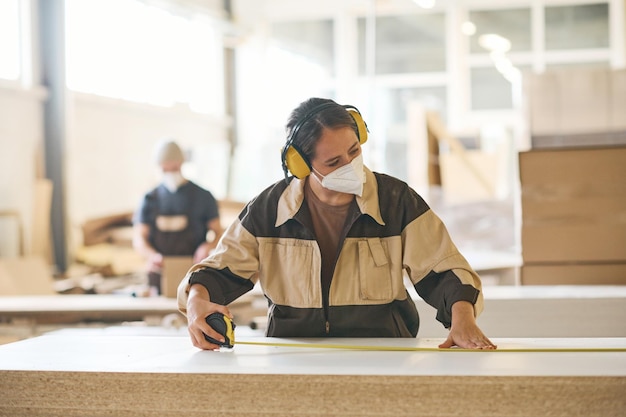 Craftsperson examining wooden material before production