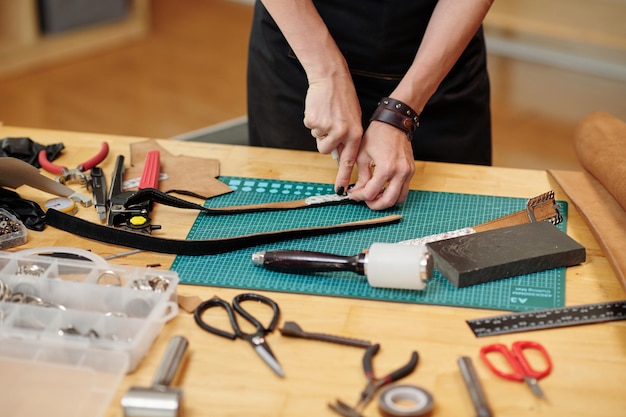 Craftsperson Making Holes in Leather Belt