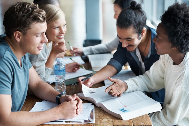 Cramming prima di un esame un gruppo di studenti universitari seduti insieme e studiando