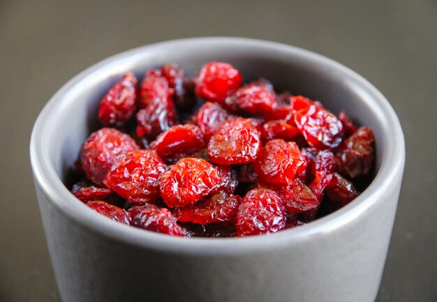 Cranberries in a bowl on a black kitchen table.